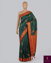 Elegant green saree with a rich red border and delicate diamond work — a perfect blend of tradition and sparkle.